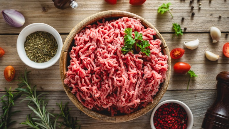 Raw ground beef in a wooden bowl