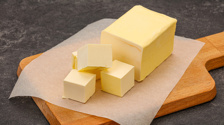 Block of butter on a wooden cutting board