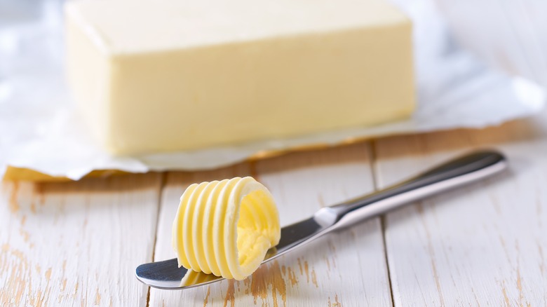 Block of butter and butter curled on a knife