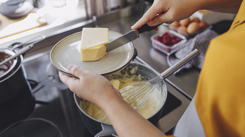 Person adding butter to a recipe