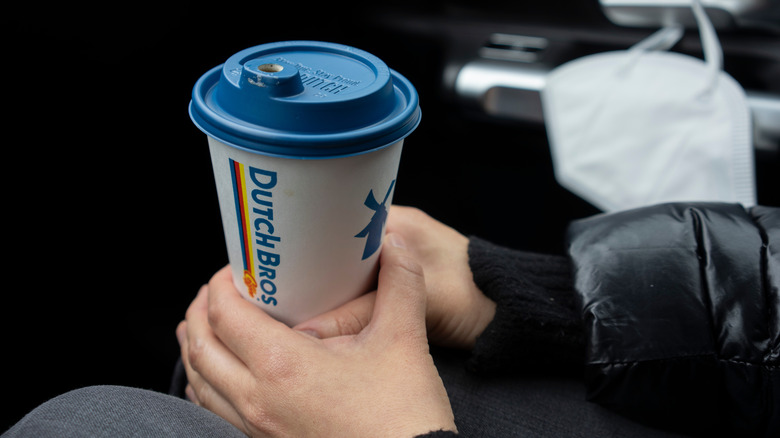 A person holding a cup of Dutch Bros. Cocomo coffee