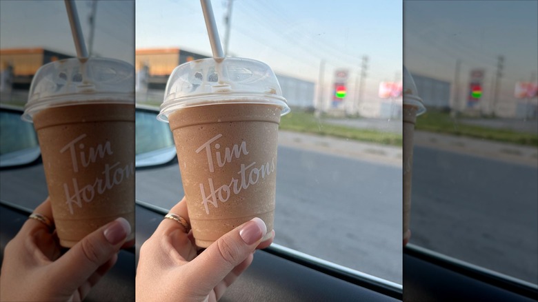 person holding a Tim Hortons Mocha Iced Capp