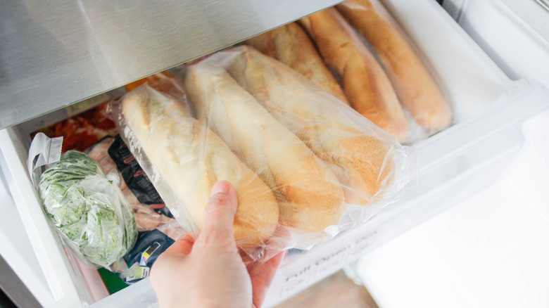 Hand grabbing frozen bread from freezer