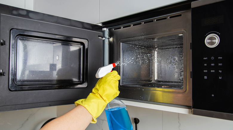 Person cleaning a microwave