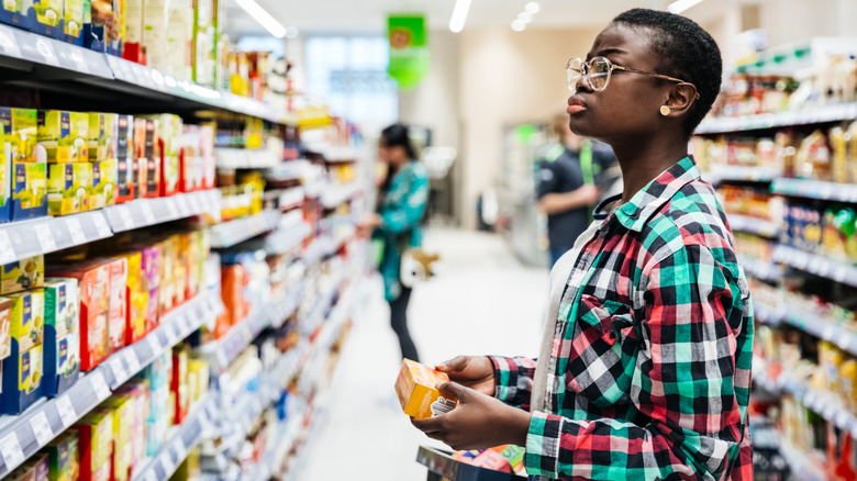 woman looking at packaged foods in grocery store