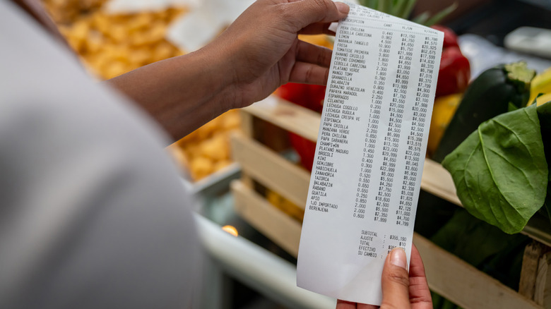 woman looking at grocery receipt