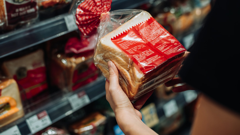 woman reading the back of packaged bread