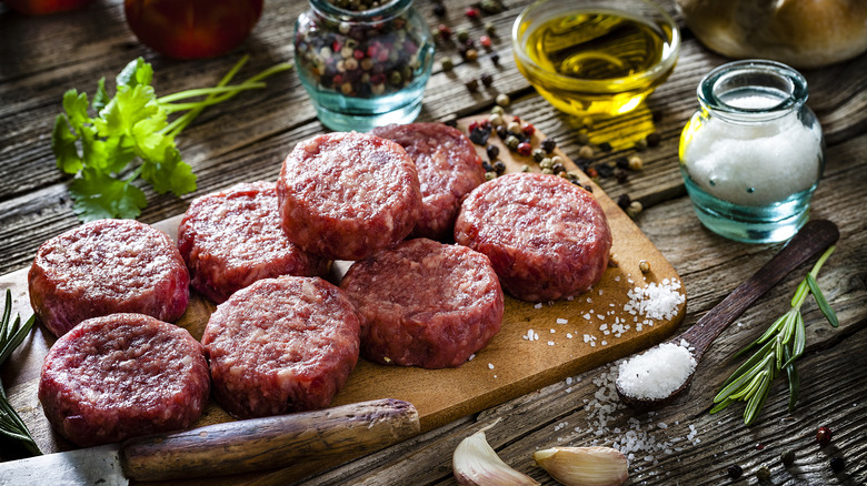 Raw burgers surrounded by ingredients