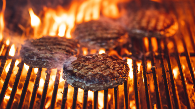 Burgers on flaming grill