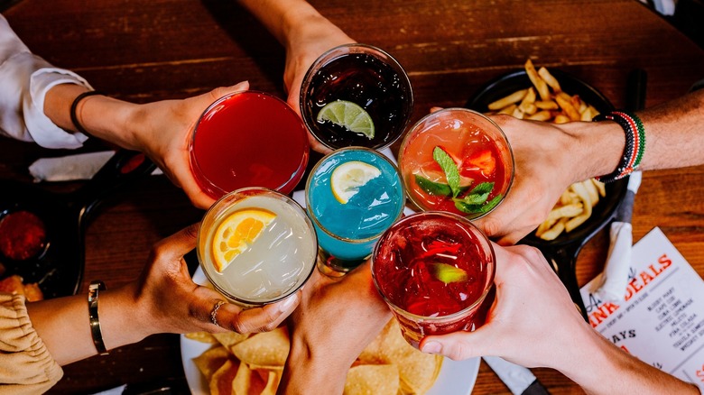 people cheers-ing in the middle of a table