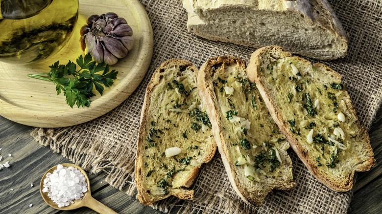 Rustic garlic bread with oil, herbs, and flaky sea salt