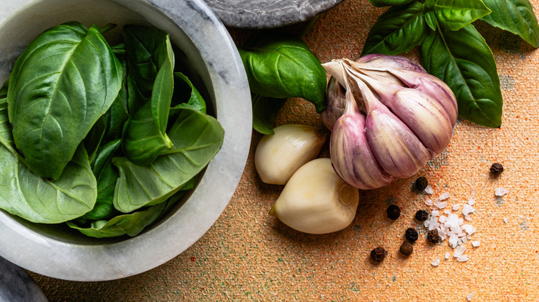 Whole garlic cloves and bulbs with fresh basil