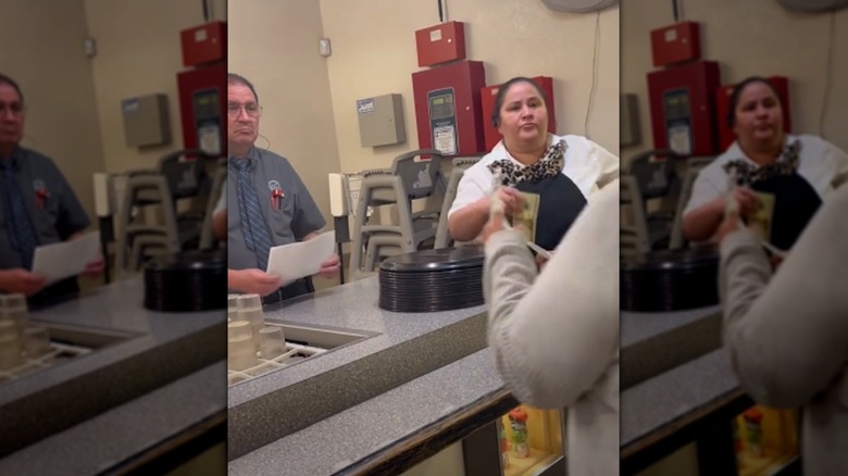 Golden Corral employees listening as woman shows them a receipt