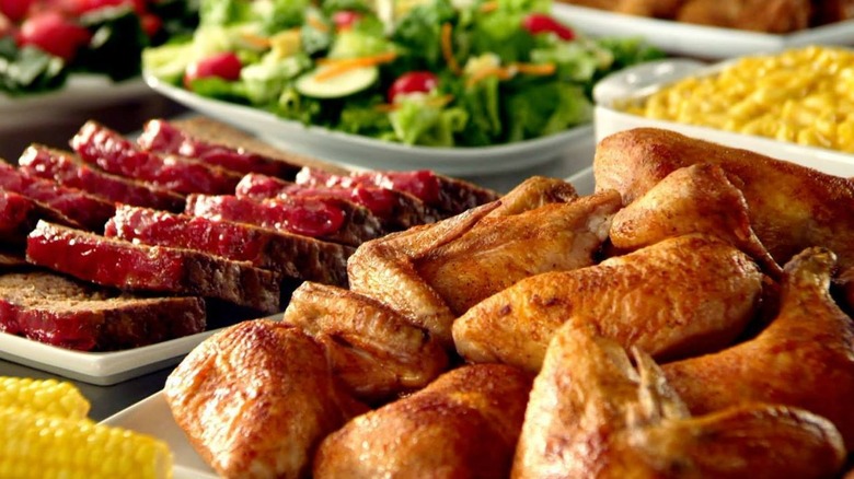 Golden Corral chicken and meatloaf in the foreground with salad and corn in the background