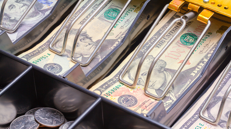 An open cash register drawer, showing various bills