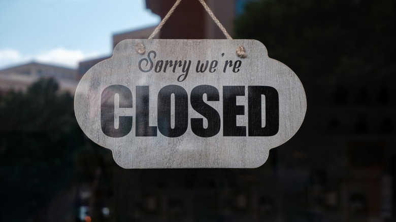 Sign in a store window that reads "Sorry we're closed"