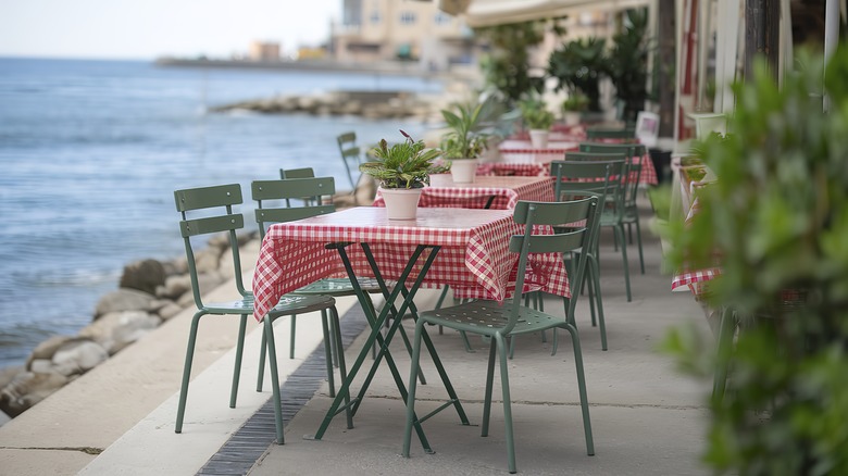 empty tables at seaside outdoor restaurant