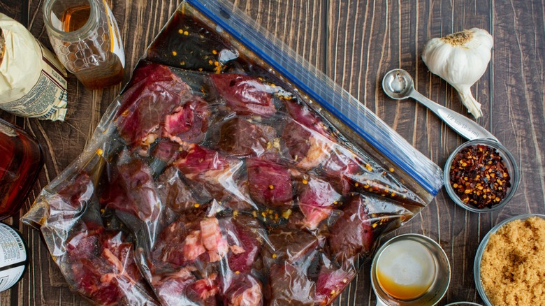 Steak marinating in bag surrounded by honey, brown sugar, and spices