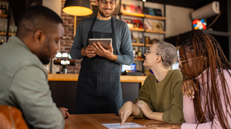 Waiter taking order from a table of guests