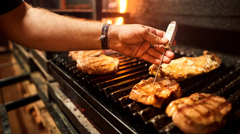 A professional chef checks the temperature of a steak