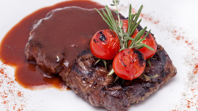 Plated steak drenched in brown sauce