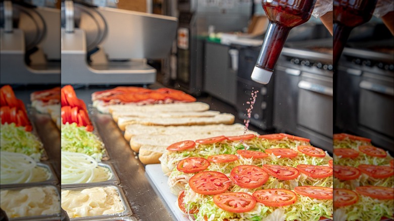 Red wine vinegar pouring onto subs