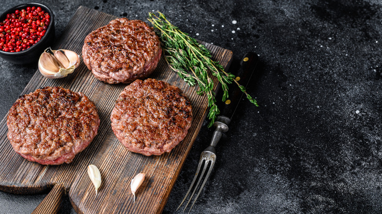 Cooked burgers on serving board