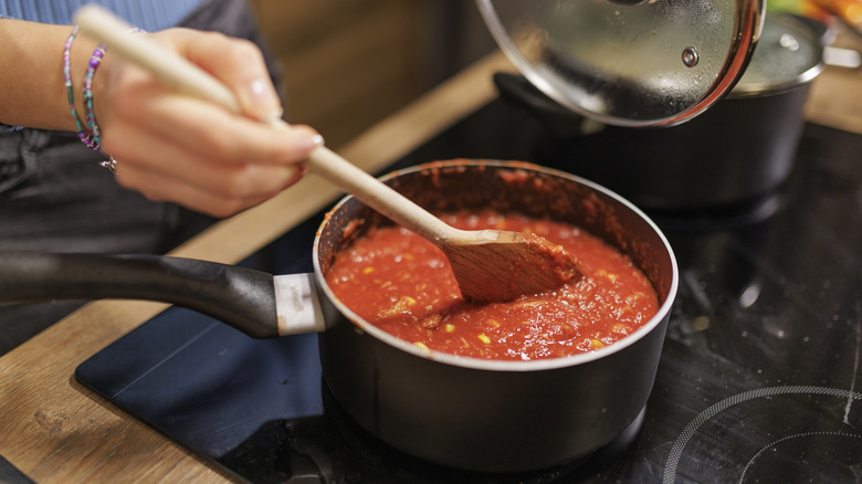 Stirring red sauce on stove