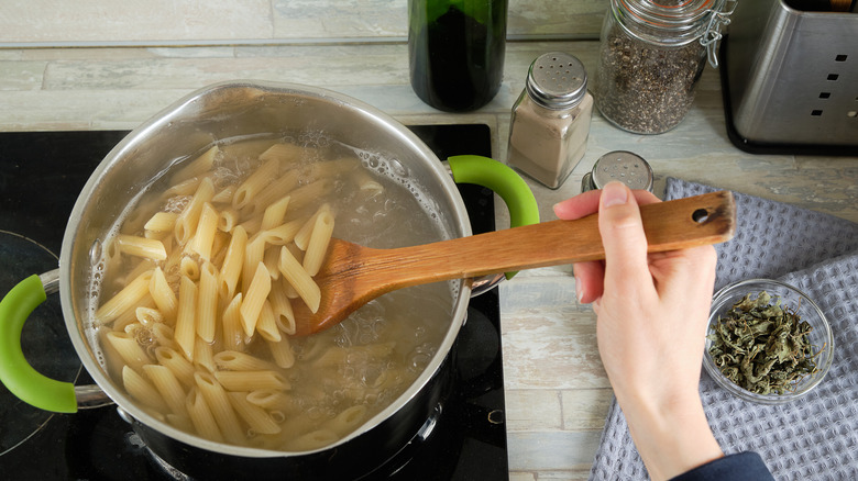 Woman stirring cooking pasta