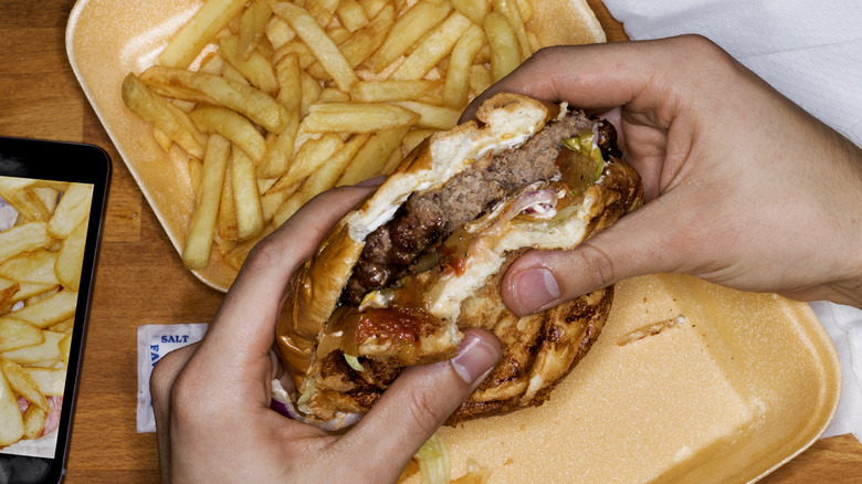 Person holding a burger