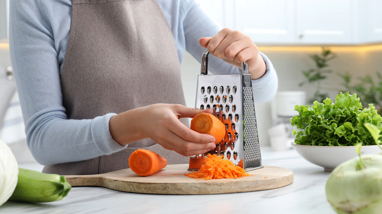 person grating carrots