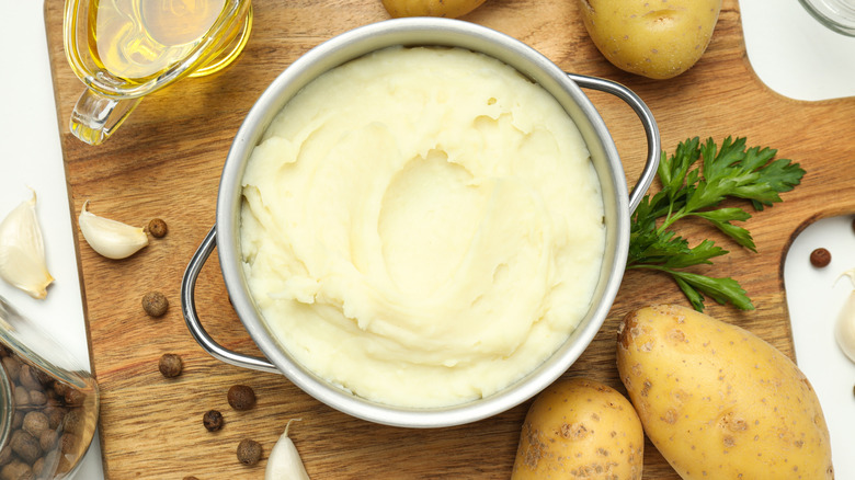 A pot filled with mashed potatoes surrounded by ingredients