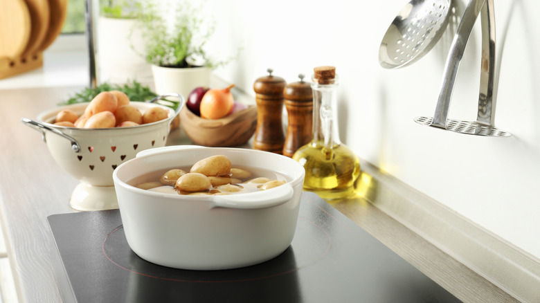 Skin-on potatoes in a pot with water on the stove