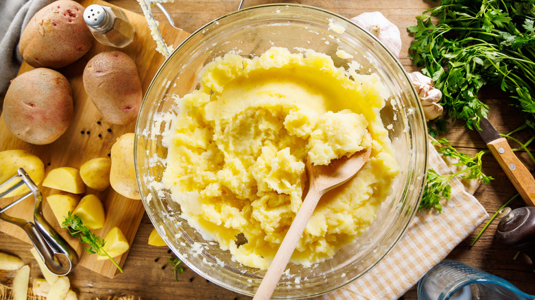 Mashed potatoes in clear bowl and surrounded by ingredients