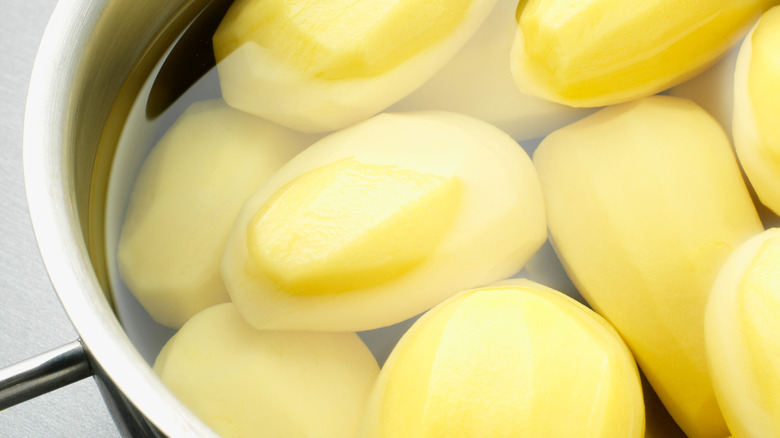 Peeled potatoes in a pot of water