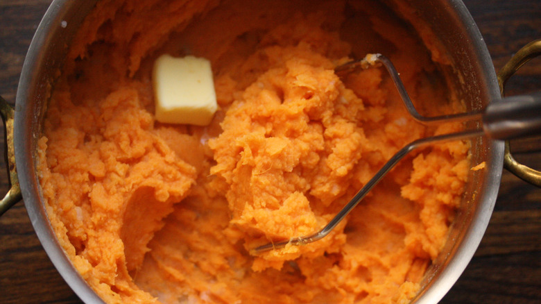 Mashed sweet potatoes in a pot with butter