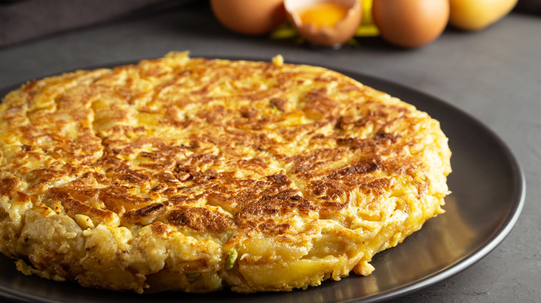 A potato cake resting on a round sheet pan