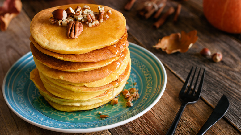 a stack of sweet potato pancakes topped with pecans