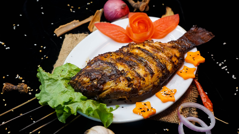 Whole grilled tilapia on plate