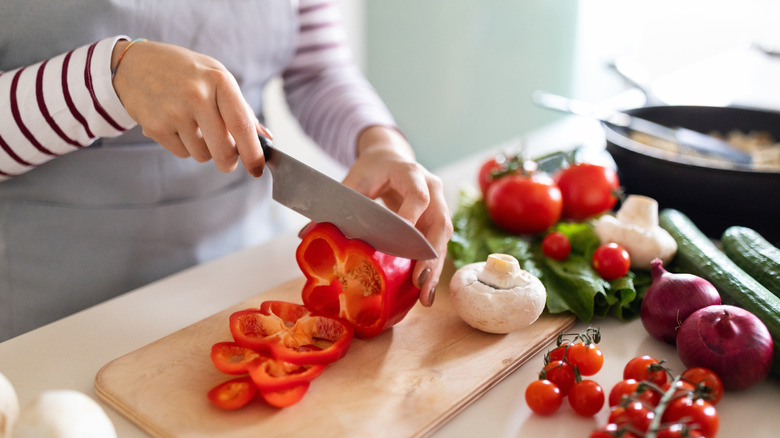 Person's hands chopping a bell pepper