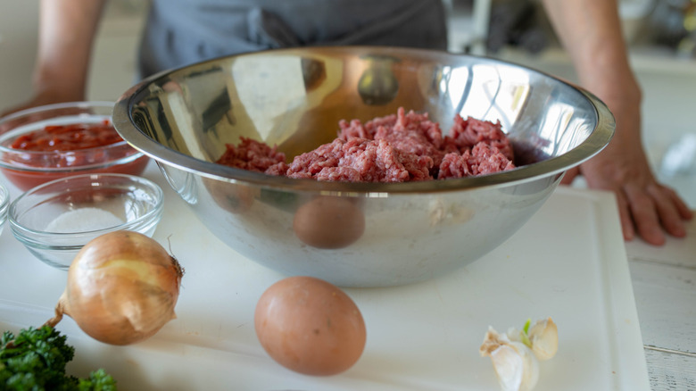 Person standing in front of raw meatloaf ingredients