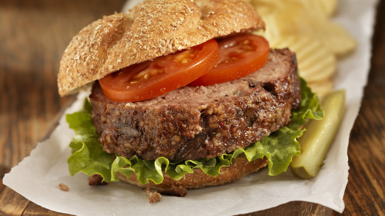 Meatloaf sandwich with chips and pickle