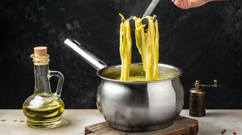 Cooked pasta with bottle of olive oil