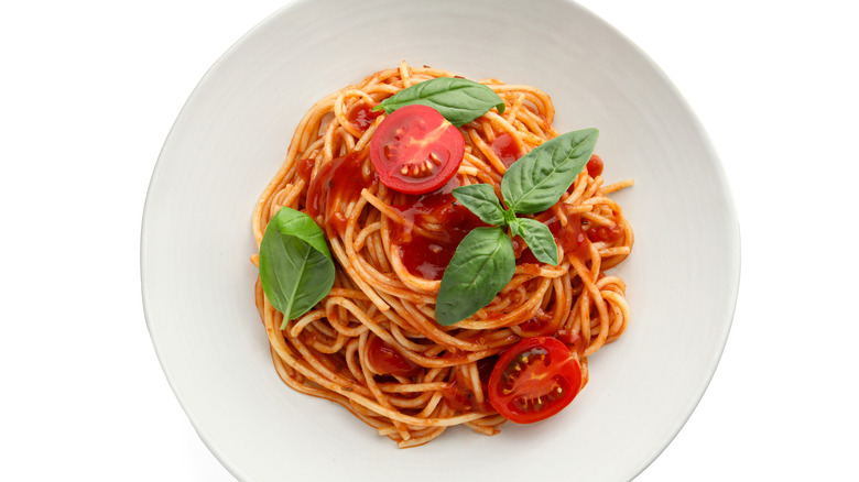 Plate of spaghetti with tomato sauce and fresh basil