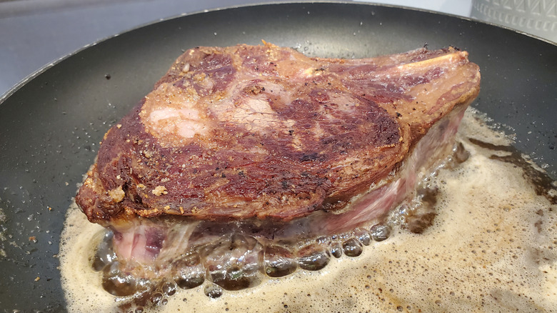 Single steak cooking in a pan