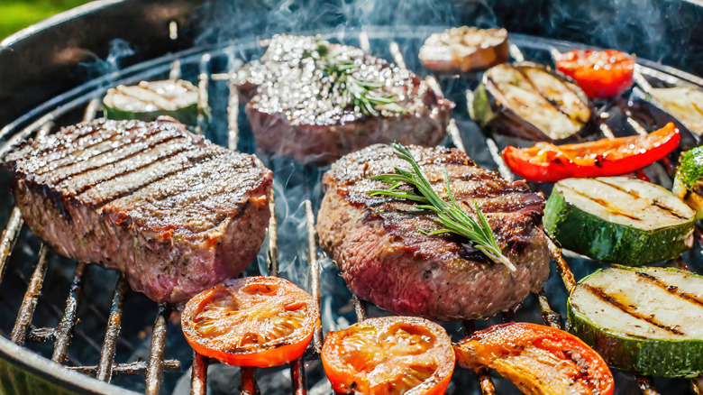 Steaks and vegetables cooking on grill