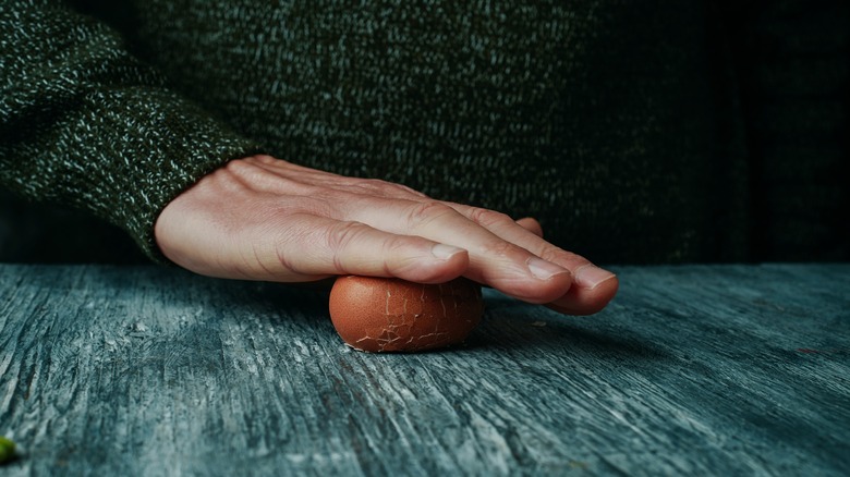 Man rolling egg on table