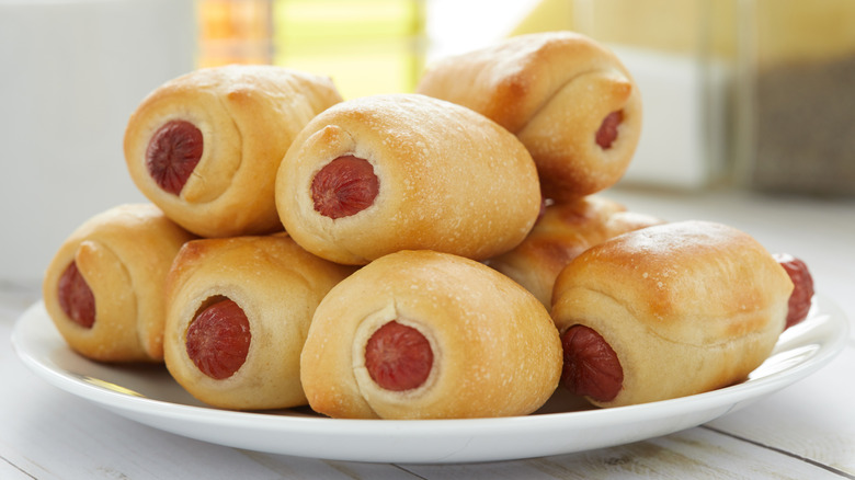 Pigs in a blanket stacked on plate