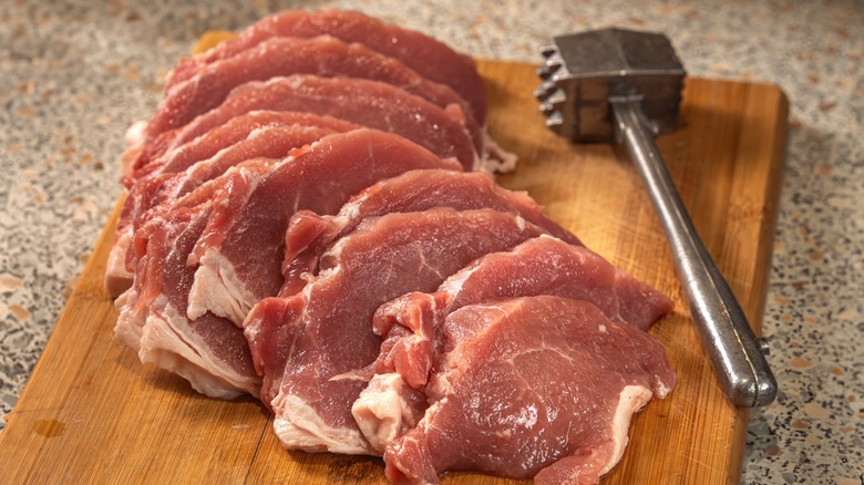 Tnederizing pork chops with a meat mallet