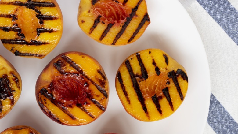 halved blackened peaches on white plate